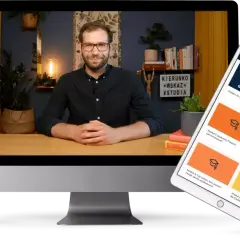 Mężczyzna siedzi przy biurku, przed nim tablet i telefon z pytaniami do przemyślenia.