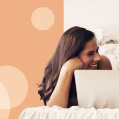 Para, przeglądająca w łóżku inspiracje na imiona dla dziewczynek, uśmiecha się do siebie.