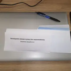 Dokument "Rozwiązanie umowy o pracę bez wypowiedzenia (Zwolnienie dyscyplinarne)" na laptopie z długopisem.