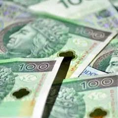 Stos polskich banknotów stuzłotowych z wizerunkiem króla.