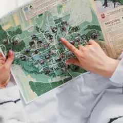 Dłoń wskazująca palcem na mapę Nałęczowa z zaznaczonymi atrakcjami.
