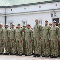 Grupa funkcjonariuszy SOP w mundurach stoi w szeregu na tle budynku.
