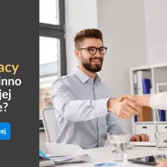 Mężczyzna i kobieta ściskają sobie dłonie przy biurku.
