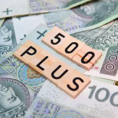 Litery "500 PLUS" na tle polskich banknotów. Symbol wsparcia finansowego, np. 500 plus dla niepełnosprawnych.