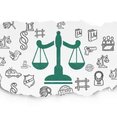 Zielona waga sprawiedliwości na tle szkiców symboli prawnych i urzędowych.