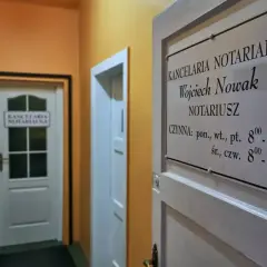 Tabliczka z nazwą kancelarii notarialnej Wojciecha Nowaka i godzinami otwarcia.