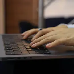 Dłonie piszą na klawiaturze laptopa. Z-15 to model, który ułatwia pracę.