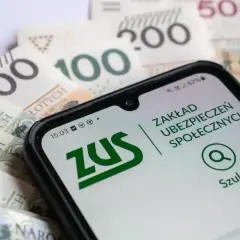 Telefon z aplikacją ZUS na tle polskich banknotów.