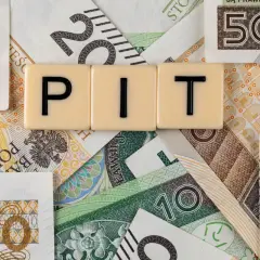Rozliczenie dochodów z zagranicy przykład: litery PIT na tle polskich banknotów o nominałach 10, 20, 100, 200 i 500 zł.