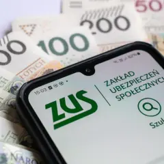 Telefon z aplikacją ZUS na tle polskich banknotów.
