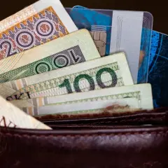 Portfel z polskimi banknotami (200 zł, 100 zł) i kartami płatniczymi.