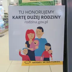 Tu honorujemy kartę dużej rodziny. Uśmiechnięta rodzina z dziećmi na plakacie.
