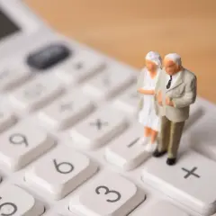 Figurki starszej pary na kalkulatorze symbolizują obliczenia związane z emeryturami stażowymi. Najnowsze informacje o zmianach w przepisach.