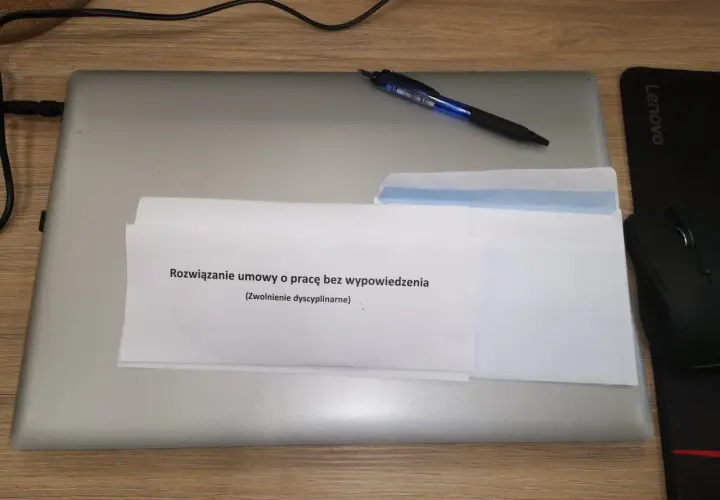 Dokument "Rozwiązanie umowy o pracę bez wypowiedzenia (Zwolnienie dyscyplinarne)" na laptopie z długopisem.
