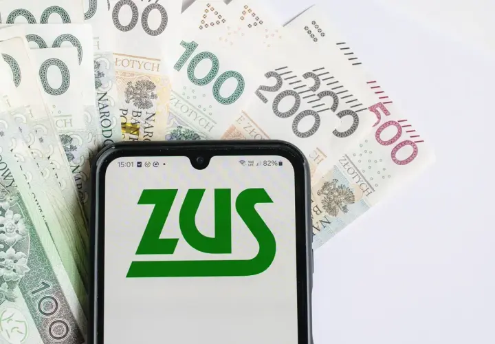 ZUS na ekranie telefonu, obok banknotów 100, 200 i 500 zł. Planowanie emerytury w Polsce.