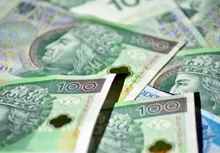 Stos polskich banknotów stuzłotowych z wizerunkiem króla.