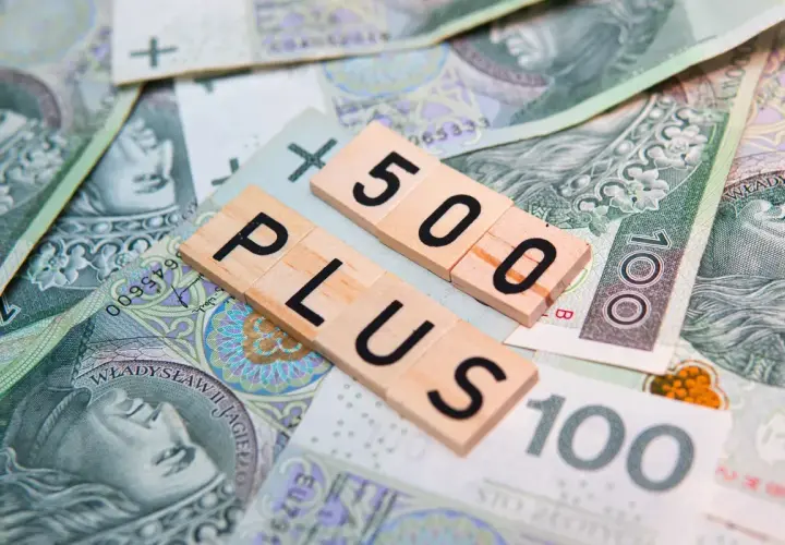 Litery "500 PLUS" na tle polskich banknotów. Symbol wsparcia finansowego, np. 500 plus dla niepełnosprawnych.