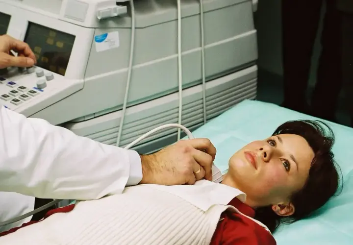 Lekarz wykonuje USG szyi pacjentce. Dostęp do opieki medycznej, w tym badań, jest ważny, nawet gdy szukasz pracy i masz ubezpieczenie zdrowotne dla bezrobotnych.