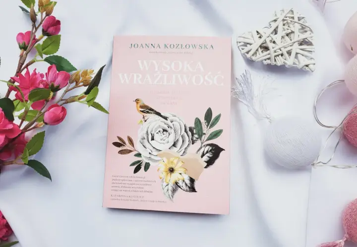 Różowa okładka książki "Wysoka wrażliwość" z motywem kwiatów i ptaszka, otoczona dekoracjami.