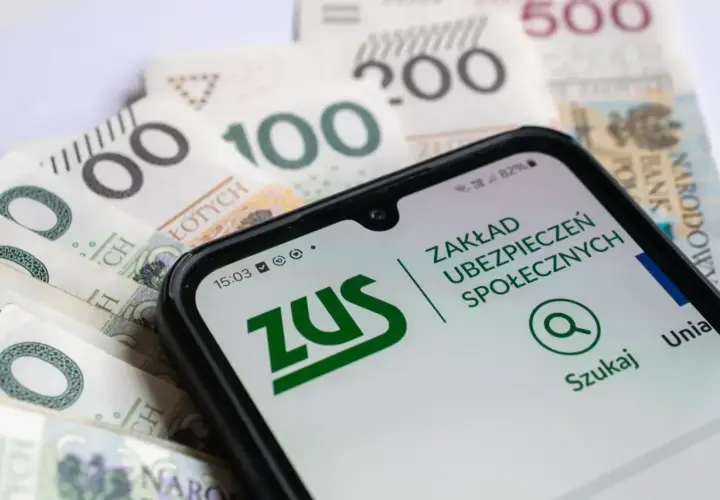 Telefon z aplikacją ZUS na tle polskich banknotów.