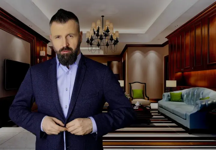 Mężczyzna w garniturze zapina marynarkę w eleganckim salonie.