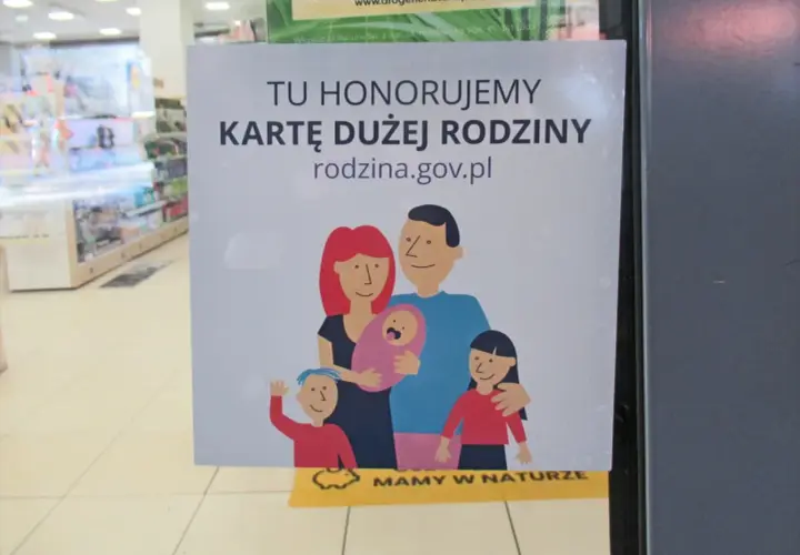 Tu honorujemy kartę dużej rodziny. Uśmiechnięta rodzina z dziećmi na plakacie.