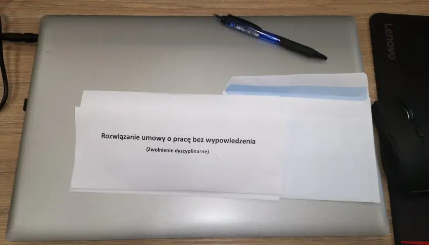 Dokument "Rozwiązanie umowy o pracę bez wypowiedzenia (Zwolnienie dyscyplinarne)" na laptopie z długopisem.