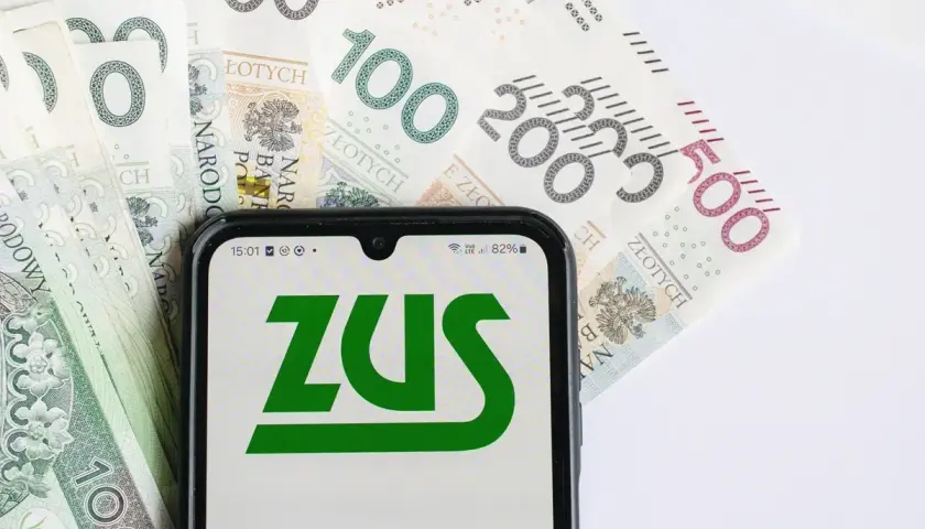 ZUS na ekranie telefonu, obok banknotów 100, 200 i 500 zł. Planowanie emerytury w Polsce.