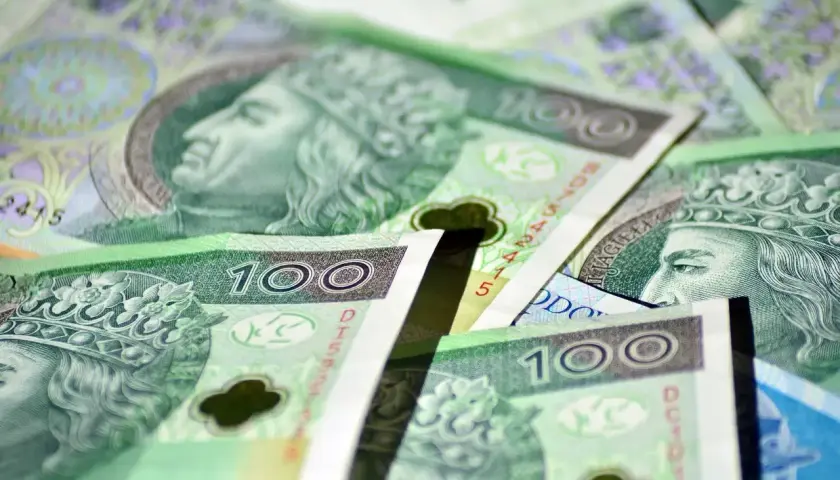 Stos polskich banknotów stuzłotowych z wizerunkiem króla.
