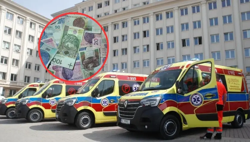 Polskie banknoty w czerwonym okręgu na tle kilku karetek pogotowia przed budynkiem.