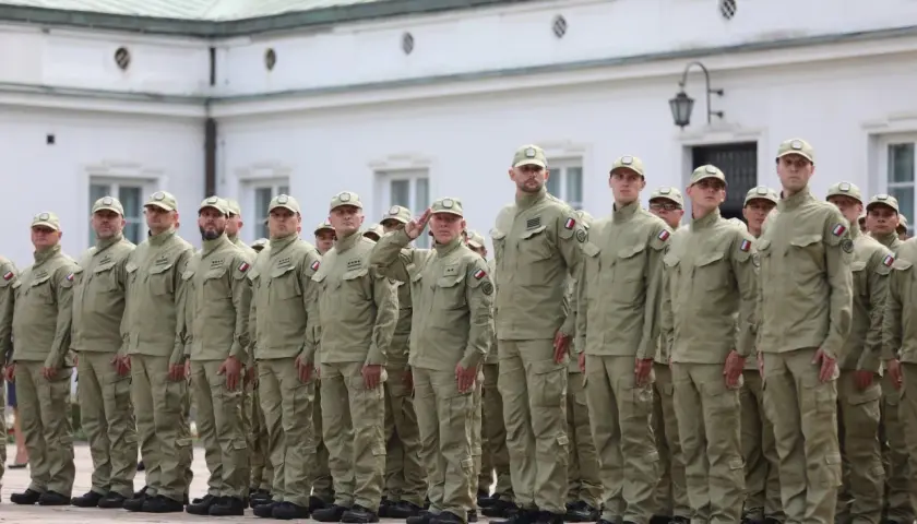 Grupa funkcjonariuszy SOP w mundurach stoi w szeregu na tle budynku.