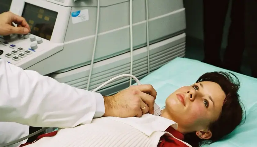 Lekarz wykonuje USG szyi pacjentce. Dostęp do opieki medycznej, w tym badań, jest ważny, nawet gdy szukasz pracy i masz ubezpieczenie zdrowotne dla bezrobotnych.