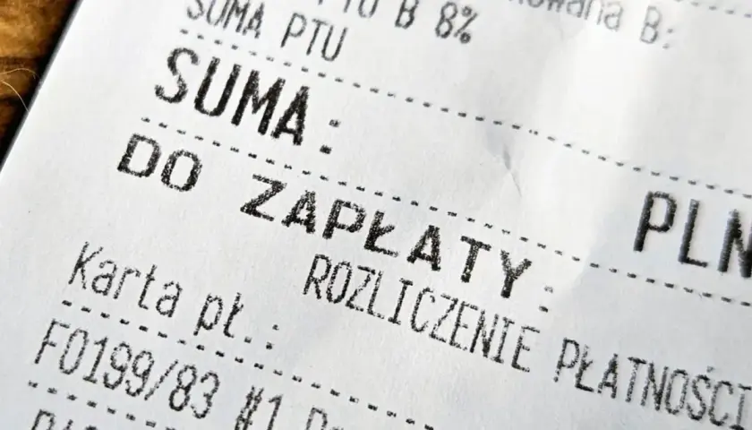 Zbliżenie na fragment paragonu fiskalnego z napisem "SUMA" i "DO ZAPŁATY".