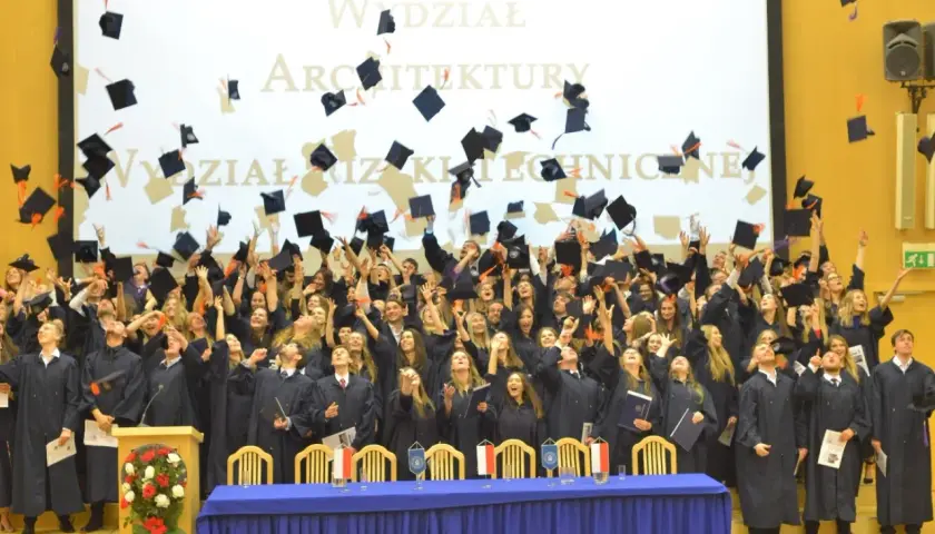 Absolwenci w togach rzucają czapki do góry na tle ekranu z napisem "Wydział Architektury Politechniki".
