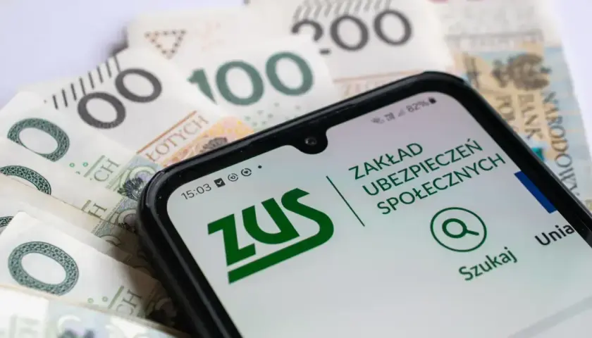 Telefon z aplikacją ZUS na tle polskich banknotów.
