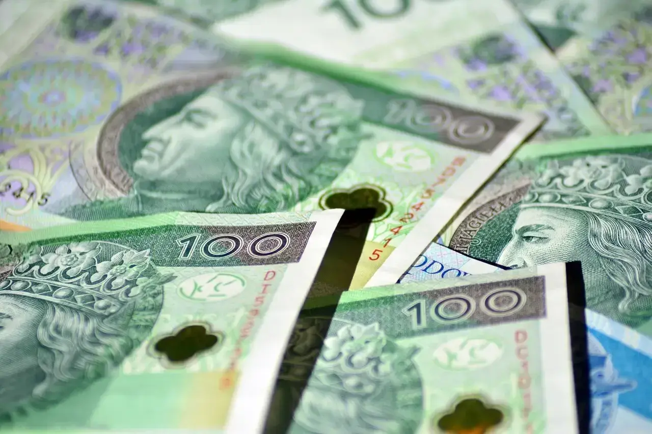 Stos polskich banknotów stuzłotowych z wizerunkiem króla.