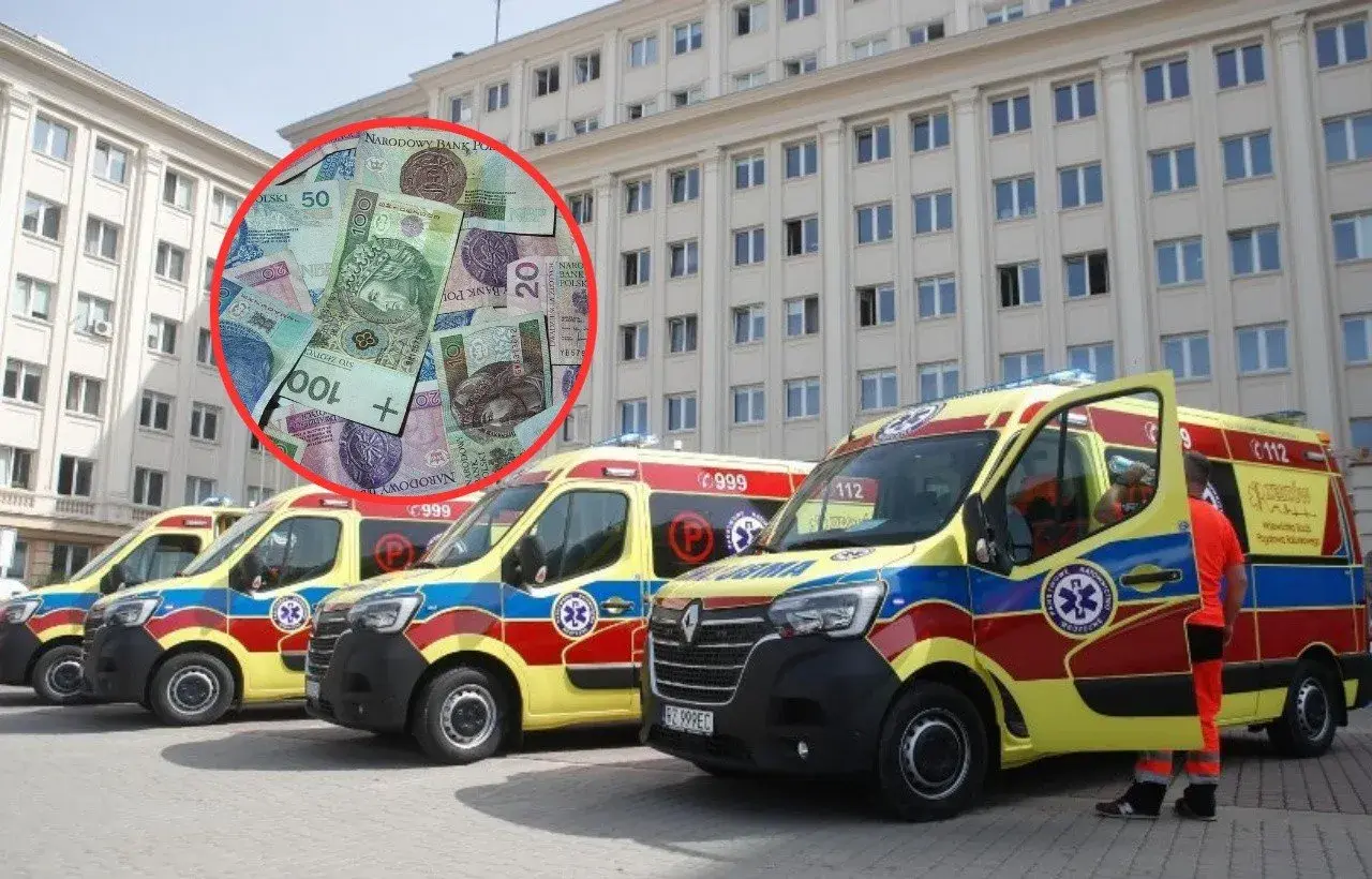 Polskie banknoty w czerwonym okręgu na tle kilku karetek pogotowia przed budynkiem.