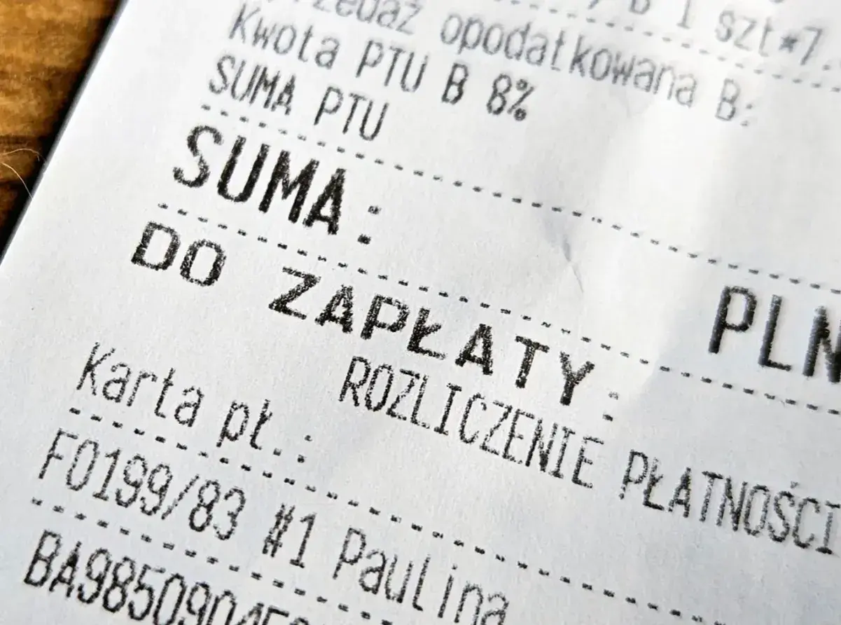 Zbliżenie na fragment paragonu fiskalnego z napisem "SUMA" i "DO ZAPŁATY".