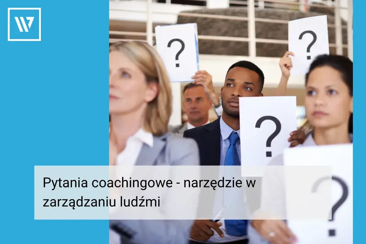 Ludzie na szkoleniu podnoszą kartki z pytajnikami. To brief o pytaniach coachingowych w zarządzaniu ludźmi.