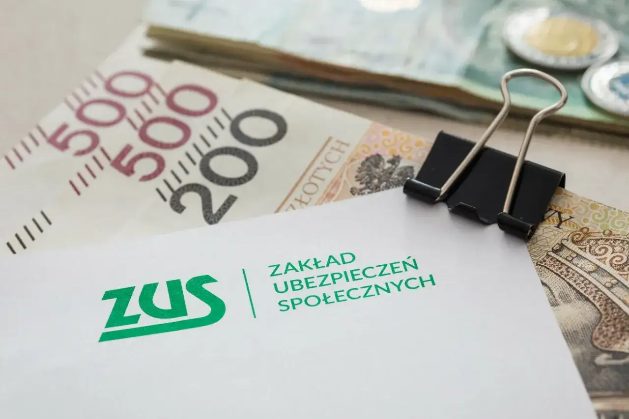 ZUS i pieniądze, symbolizujące rodzicielskie świadczenie uzupełniające. Dokument ZUS z banknotami i monetami.