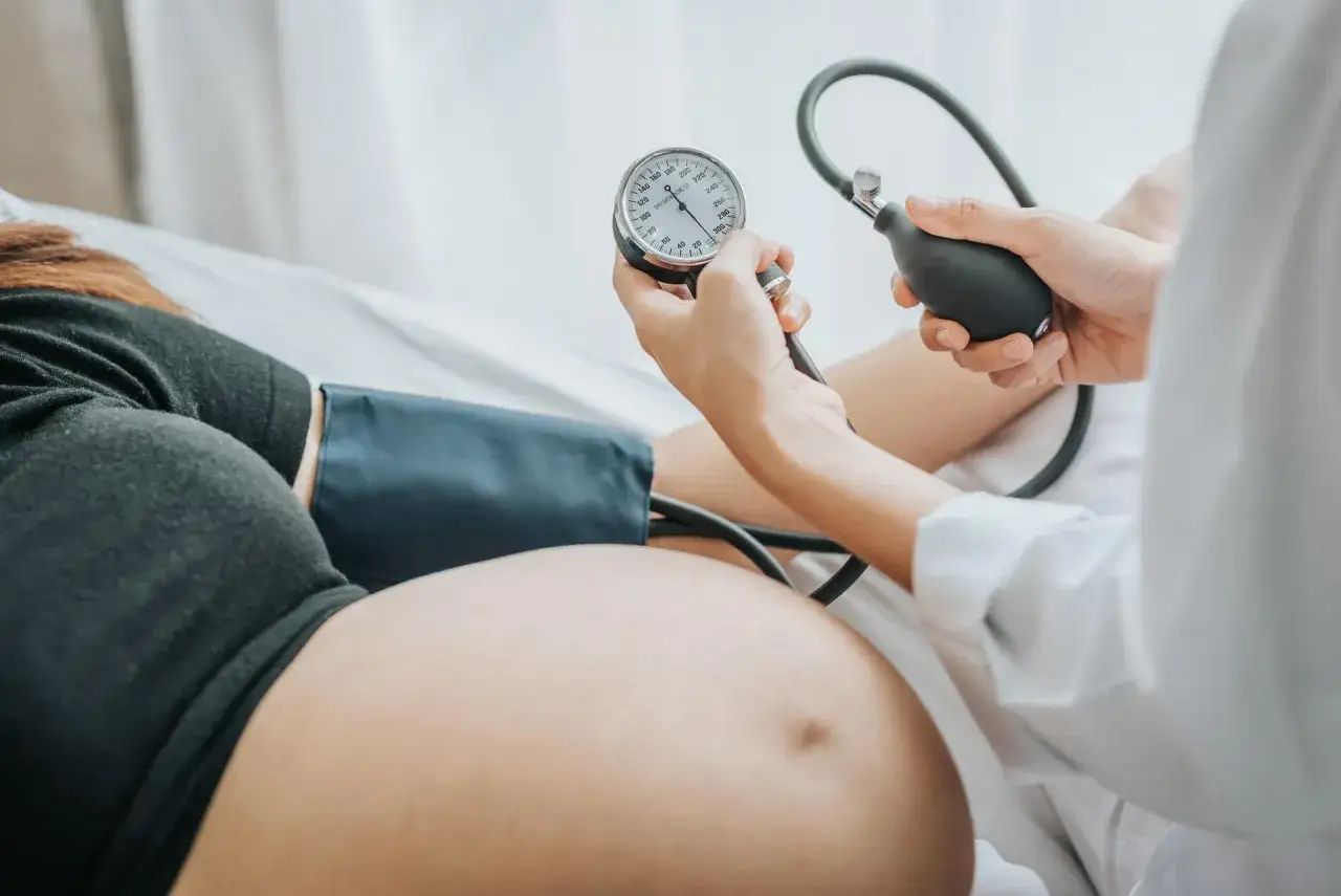 Badanie ciśnienia w ciąży. Lekarz mierzy ciśnienie ciężarnej, monitorując jej zdrowie.